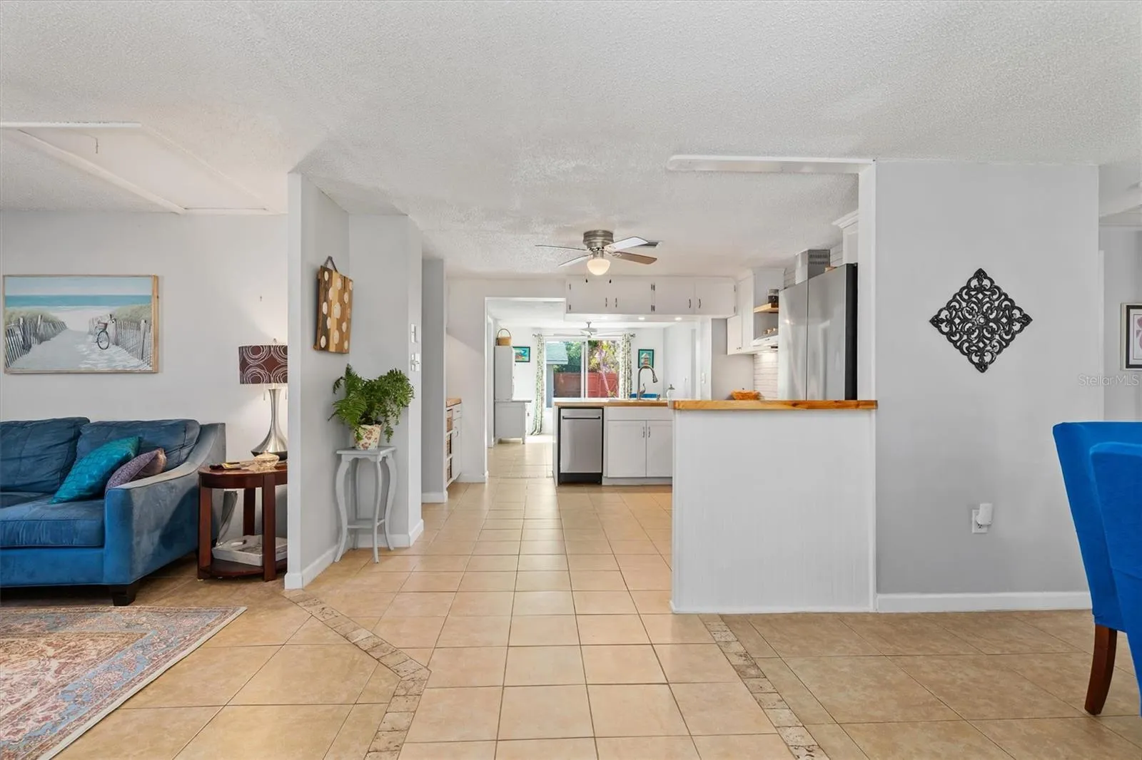 The open floor plan creates an easy connection from the front living areas through the kitchen and toward the rear of the home. Photo taken during prior occupancy.