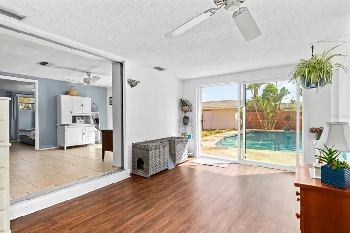 The bonus room expands the home’s living space and offers a flexible setting for a home office, hobby room, reading area or additional lounge space, with the pool and tropical backyard just outside. Photo taken during prior occupancy.
