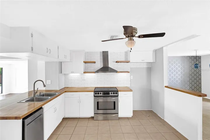 A stainless steel range and vent hood anchor the kitchen, with generous counter space for cooking and entertaining.