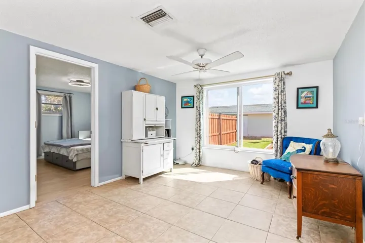 Imagine relaxing here with the pool just beyond the large picture window. This family room adds another inviting place to gather or unwind. Photo taken during prior occupancy.