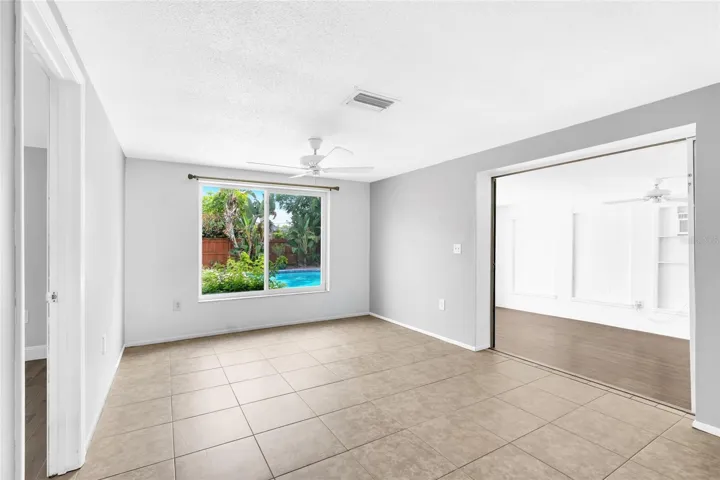 The family room offers a true second living space with a large picture window overlooking the private pool and tropical backyard.