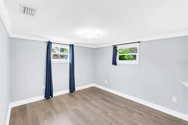 Two windows bring natural light into Bedroom 2, while updated flooring and generous proportions leave plenty of flexibility for furniture placement.