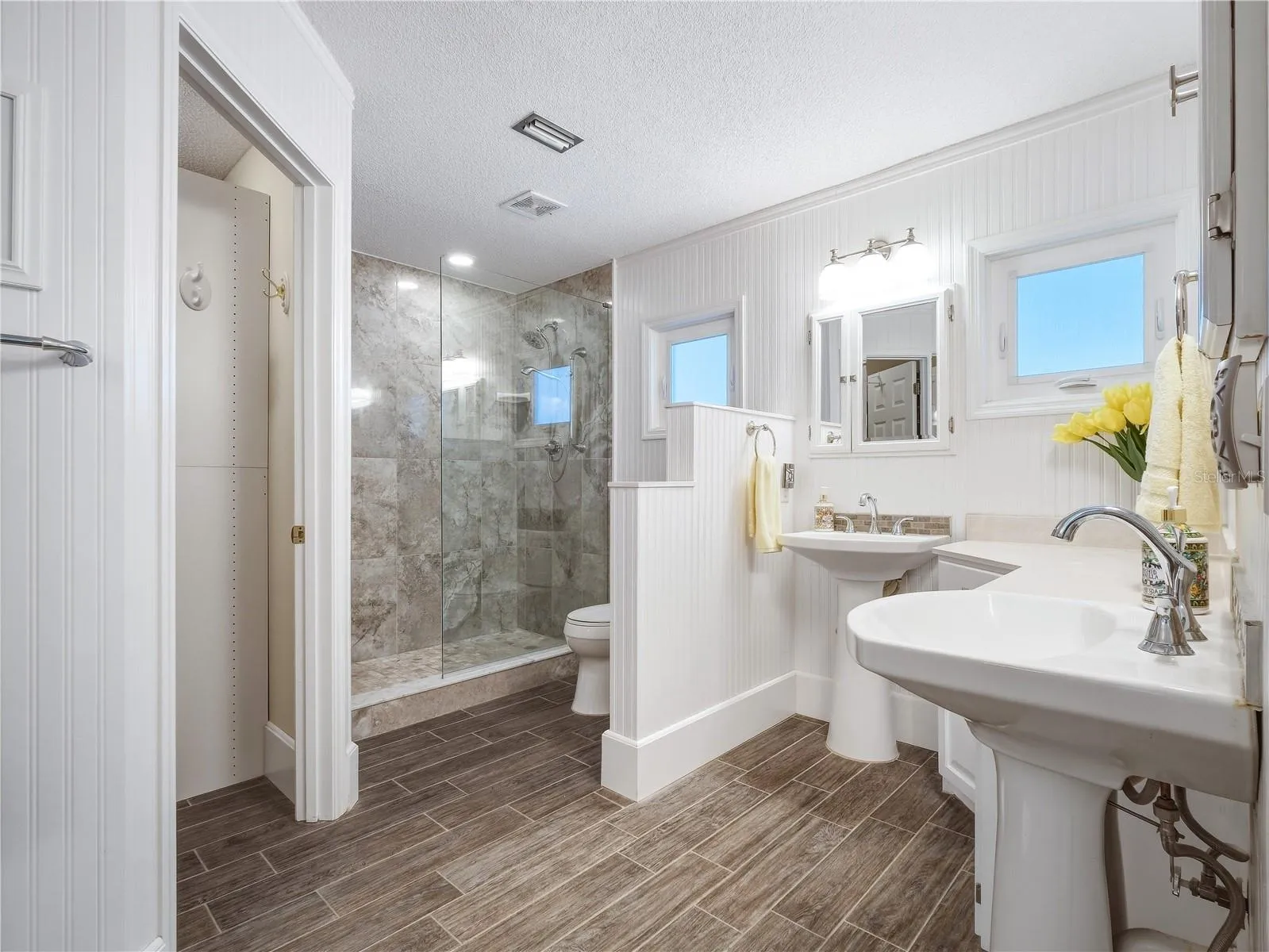 walk in shower, two closets and two pedestal sinks.