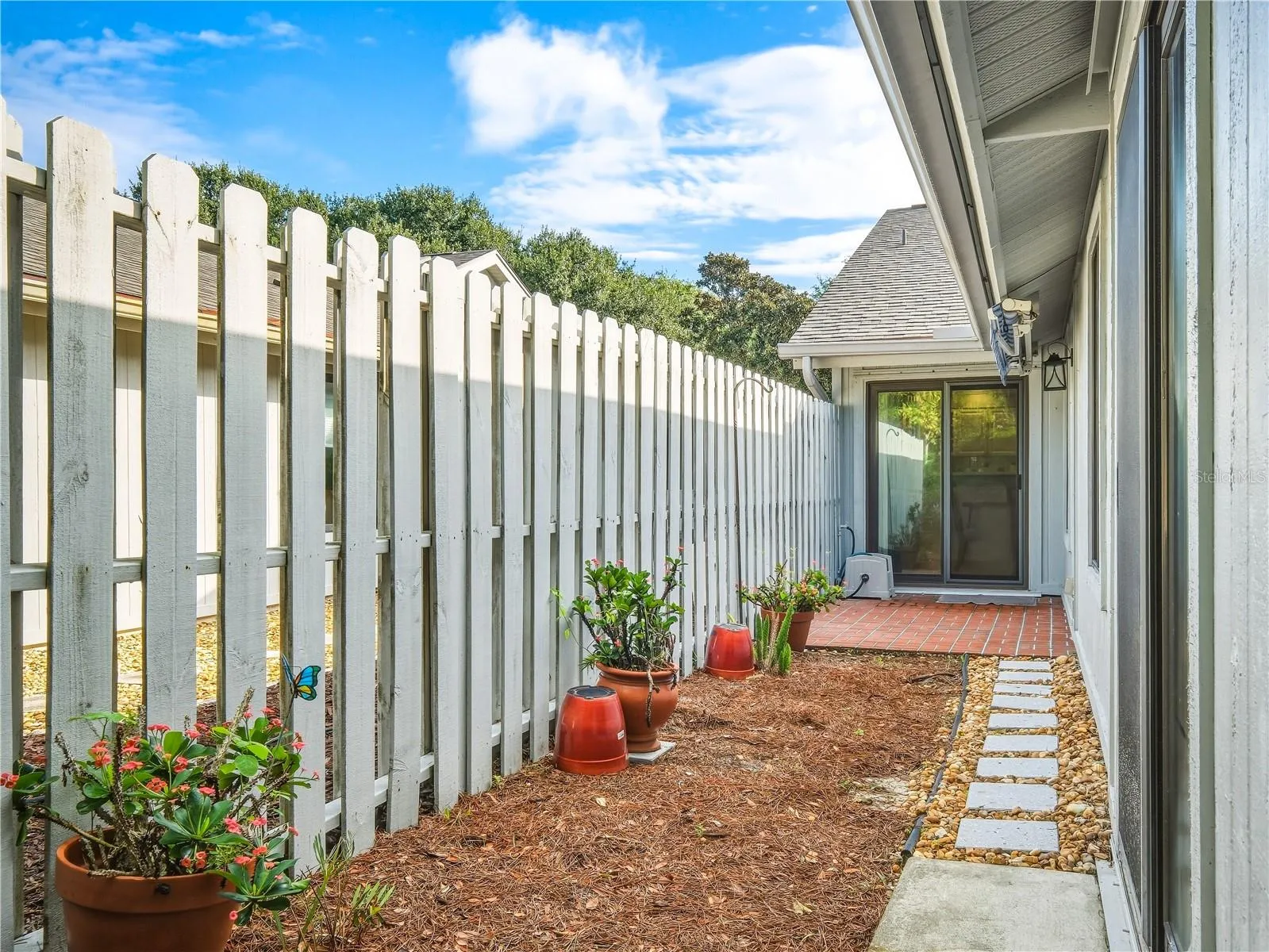 Fenced in outdoor patio with retractable awning.