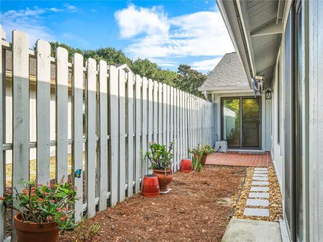 Fenced in outdoor patio with retractable awning.