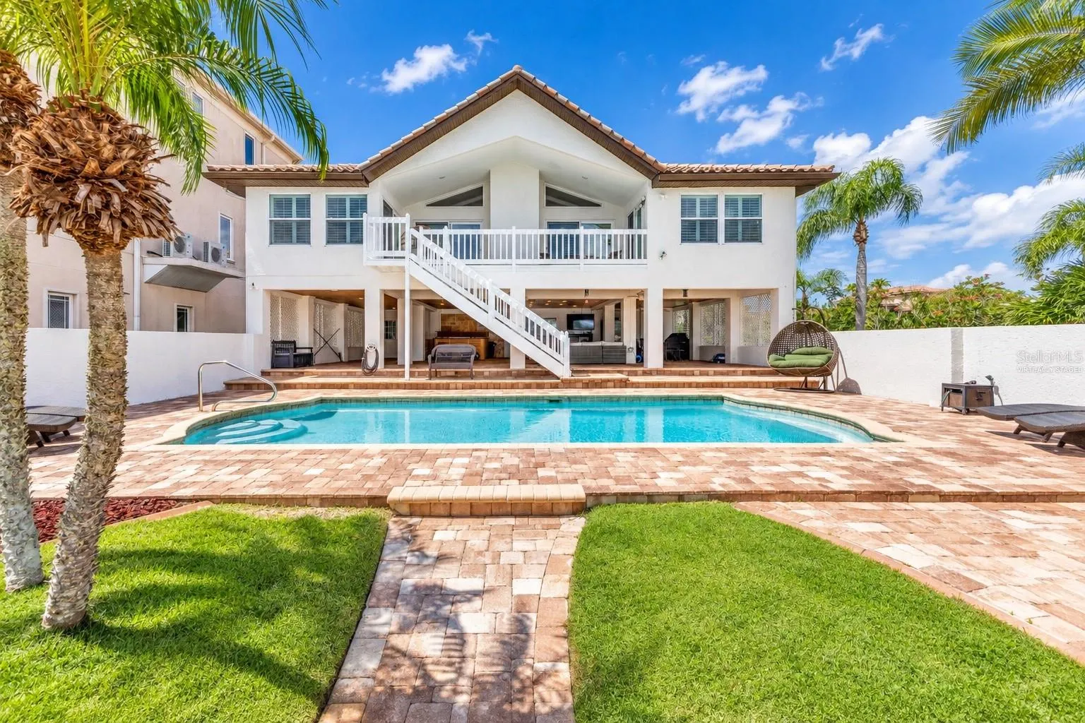 Rear exterior with heated pool, covered lanai and balcony.
