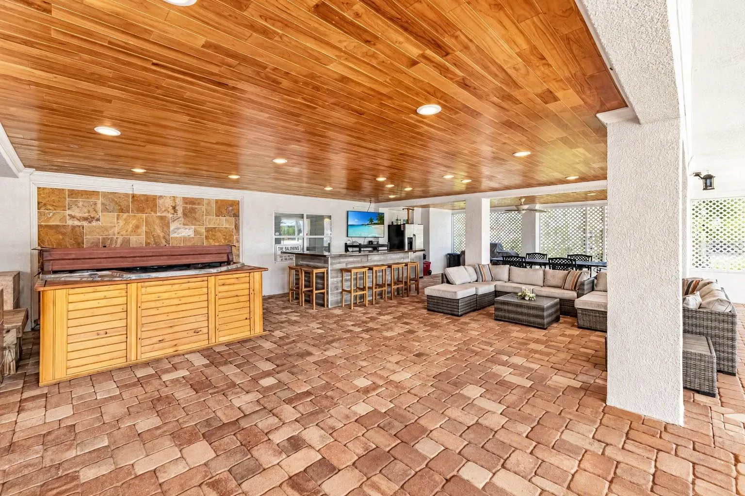 Covered entertaining area with hot tub and bar. Virtually staged – personal items digitally removed.