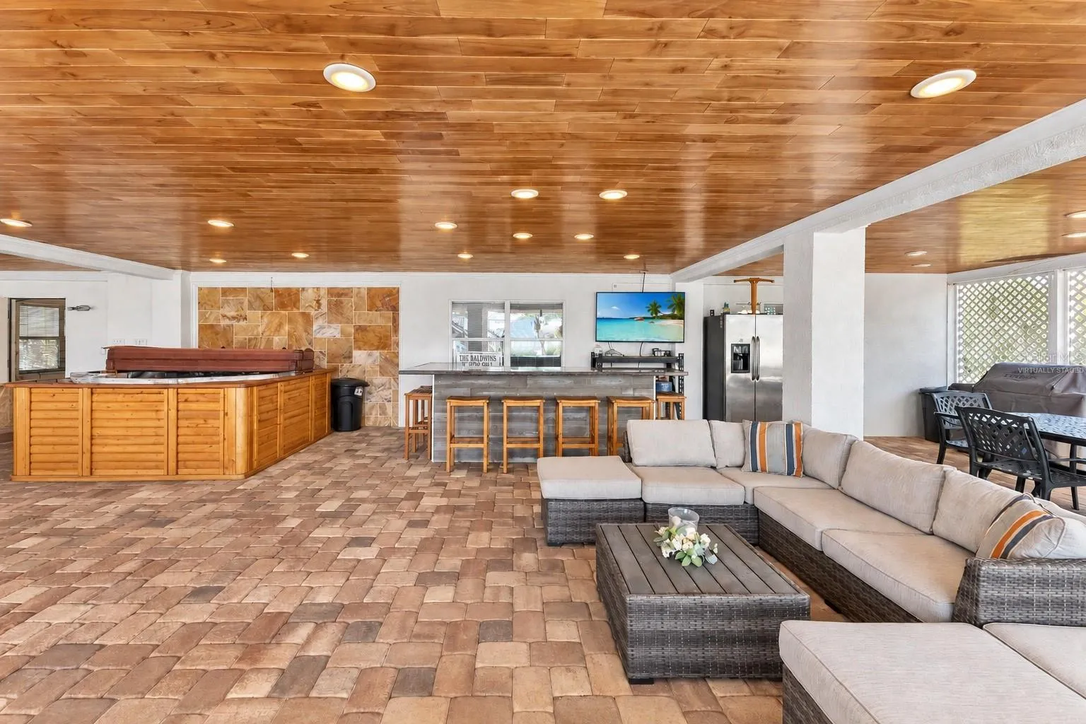 Covered lanai with bar and lounge seating. Virtually staged – personal items digitally removed.