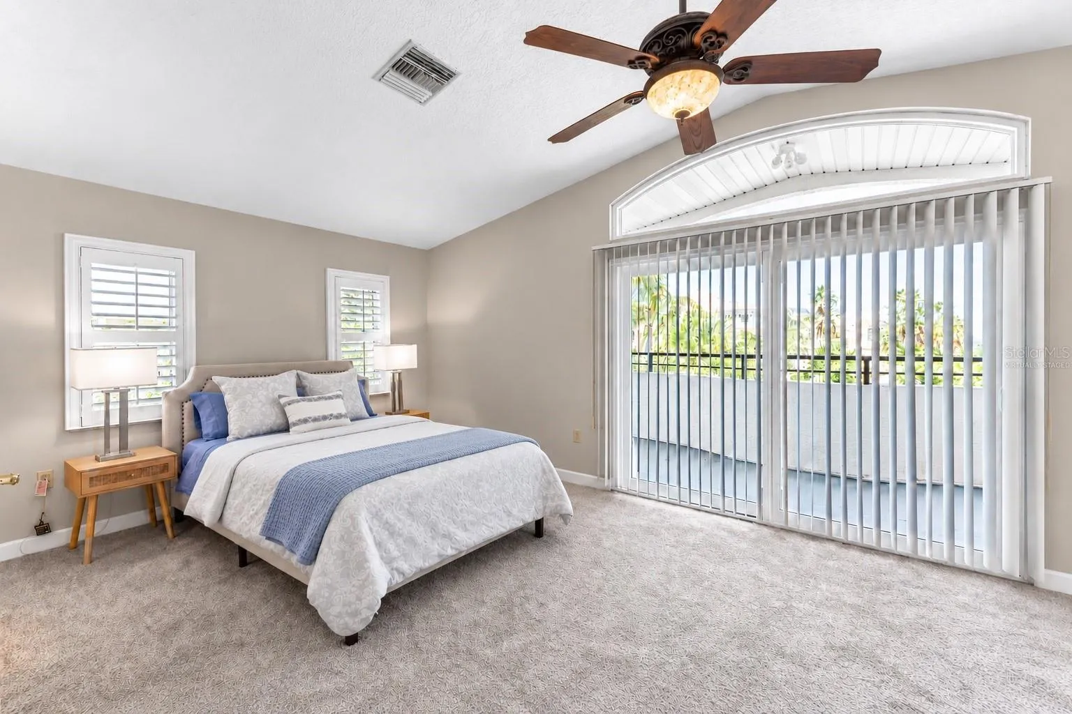Bedroom 2 suite with private balcony access. Virtually staged – bedding and decor digitally updated.