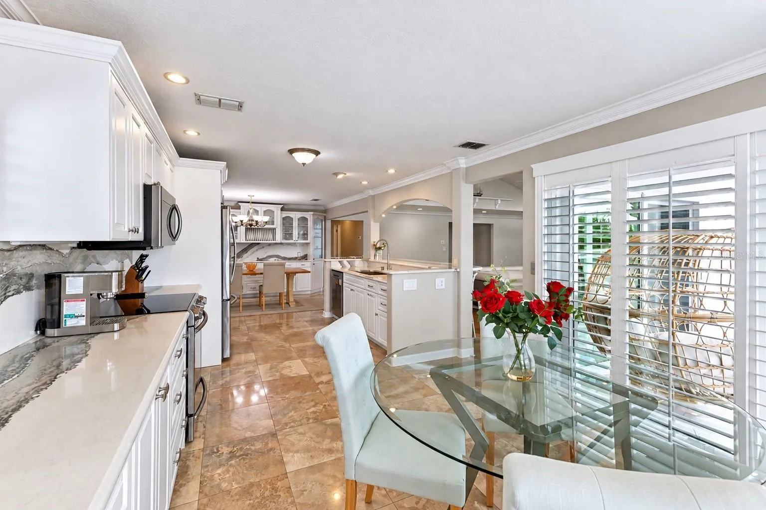 Eat-in kitchen dining area with plantation shutters and canal views.