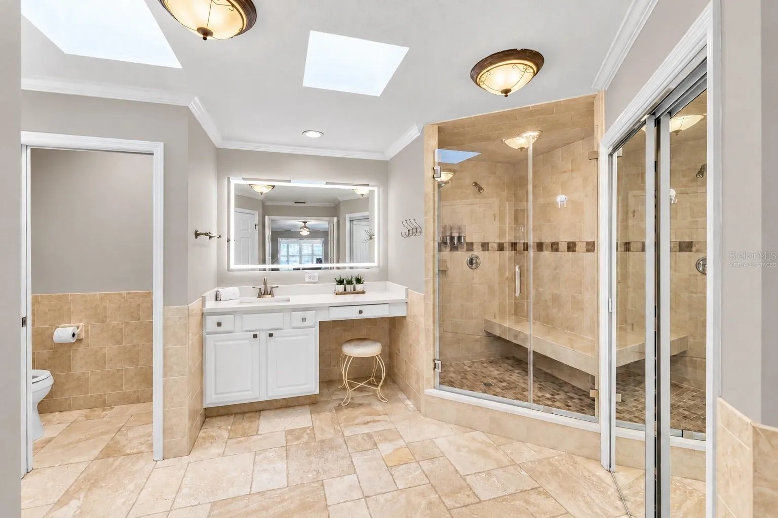 Remodeled primary bath with walk-in shower and skylights.