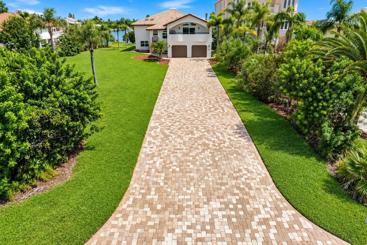 Brick-paver driveway and landscaped front yard.