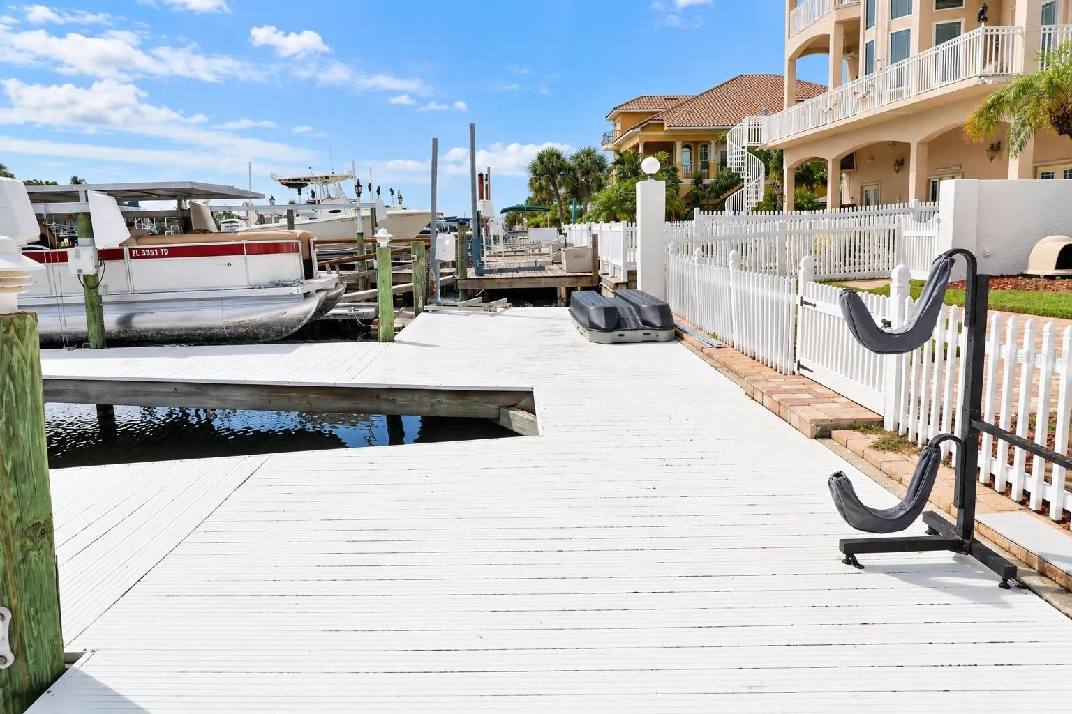 Concrete dock along the seawall with fenced backyard.