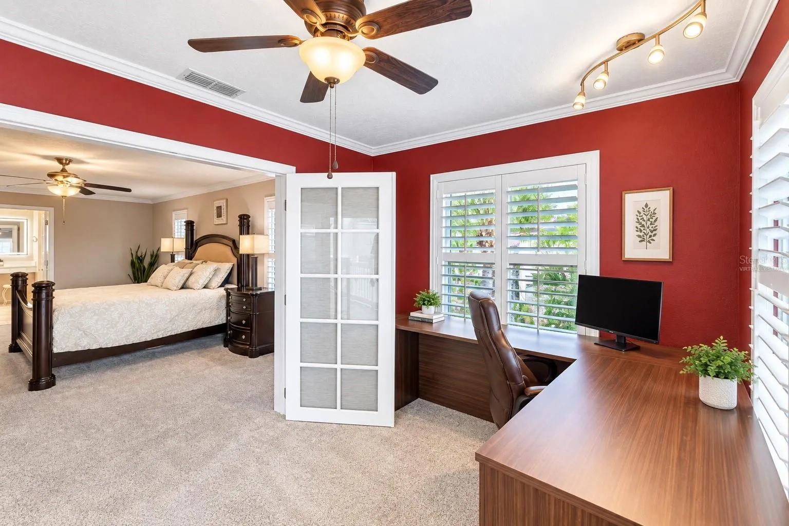 Primary suite office/den with French doors to the primary bedroom. Virtually staged – decor added and personal items digitally removed.