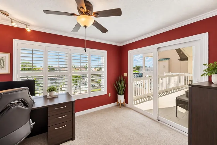 Primary suite office/den with slider to the rear balcony. Virtually staged – furniture and decor digitally changed.