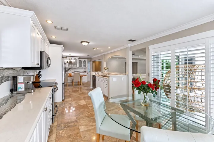 Eat-in kitchen dining area with plantation shutters and canal views.