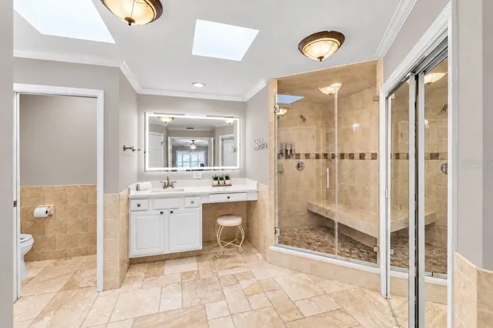 Remodeled primary bath with walk-in shower and skylights.