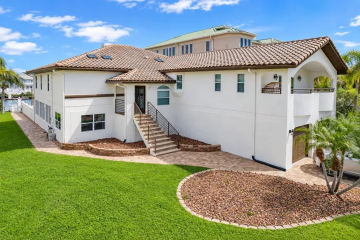 Side exterior of the elevated home with stairs to the main entry.