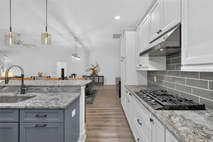 Kitchen with gas stove and tile backsplash
