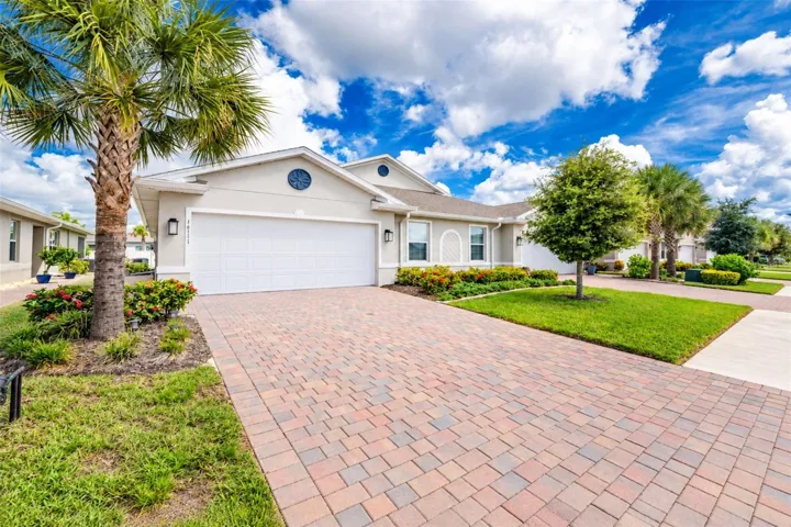 Beautifully maintained villa with attractive tropical landscaping, a spacious paver driveway and private 2-car garage. This residence is the villa located on the left side.