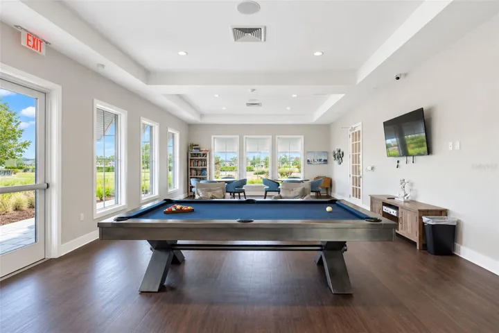 Inviting clubhouse game room featuring a pool table and comfortable gathering areas where residents come together for games, activities and social events.