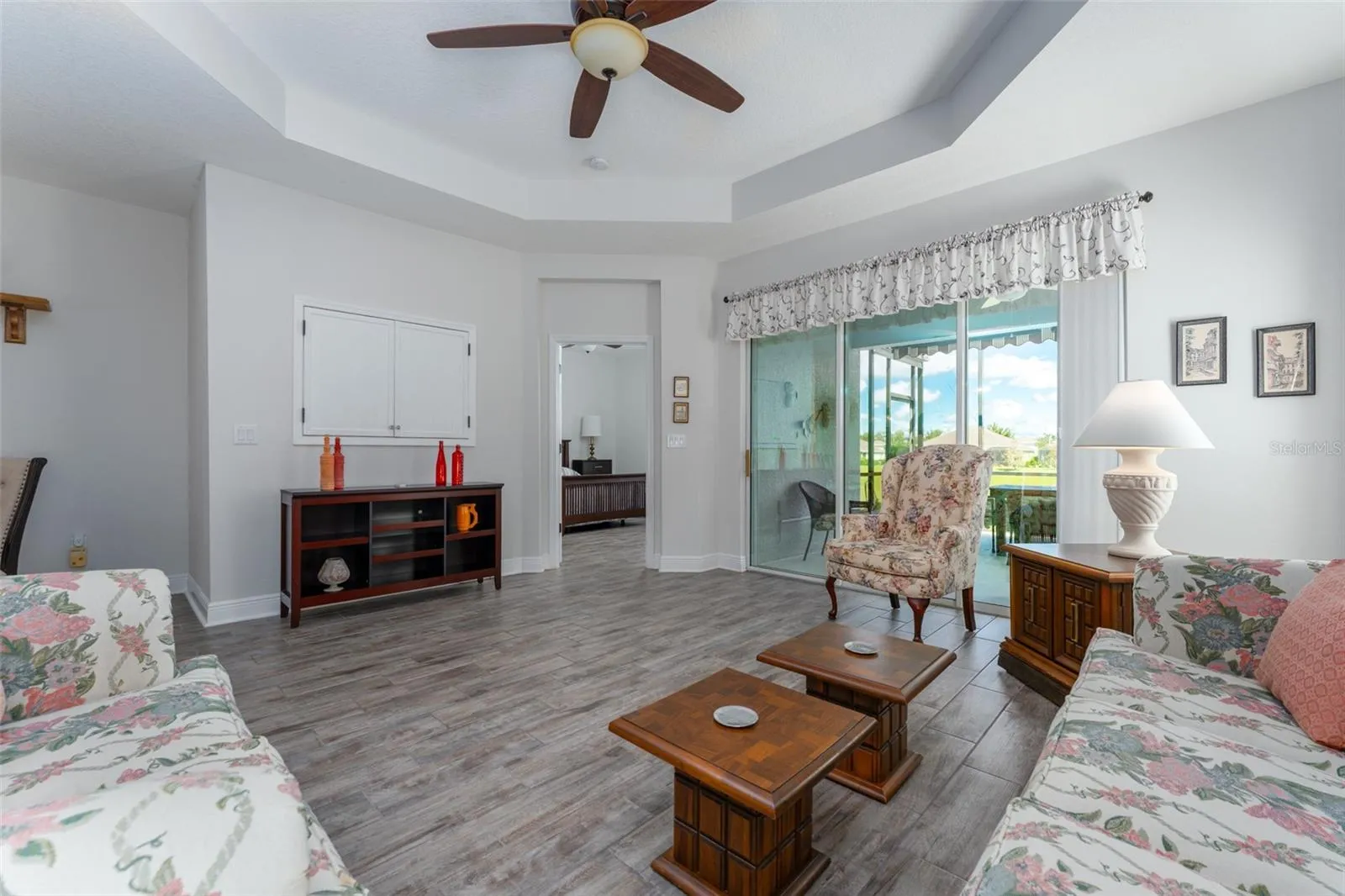 What's not to love here!! Charming light infused 2 bedroom, 2 bath villa with office in the gated village of Sagewood in Fishhawk West. Sitting pretty on a private lot with no back or side neighbors and adjacent to the wooded green space and extra parking. Walk up the sidewalk to the cozy covered front porch and screened entryway. Step inside onto neutral staggered tile flooring that flows throughout the main living areas with engineered wood flooring in the office and carpet in the two bedrooms. The kitchen features white cabinetry with crown tops, granite counters, tile backsplash and GE SS appliances including gas range/oven, microwave, fridge and Bosch dishwasher in the center island with pendant lighting and additional seating. The kitchen is open to the great room with coffered ceiling and the dining area. The great room overlooks the covered extended screened lanai accessible through sliding glass doors extending your living space to the outdoors with views to the natural green space directly behind th