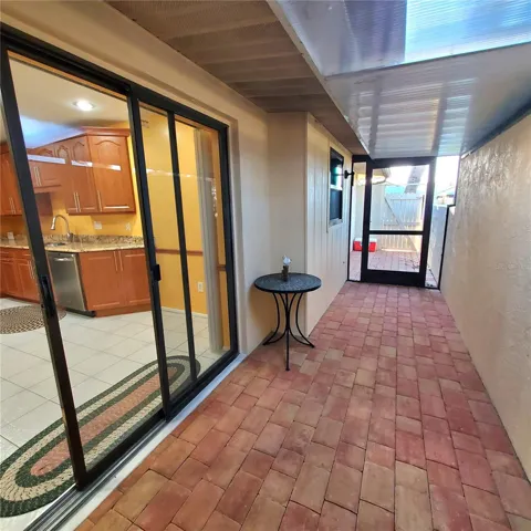 enclosed sitting area with pave stone and screen door to the back.