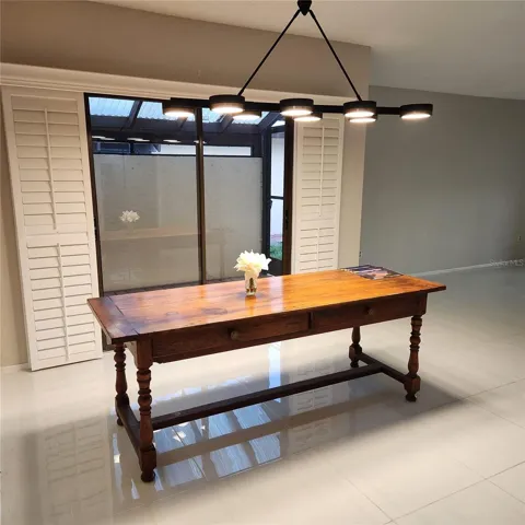 Formal dining area has a beautiful light and room for a large table to seat 8.  The sliders to the enclosed outdoor sitting area have Plantation shutters so you can have a classy formal dining area.