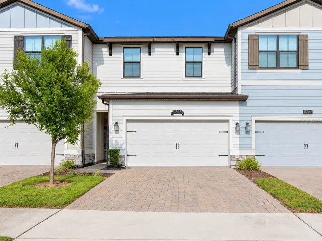 Front Exterior: Well-maintained townhome with a two-car garage and paver driveway.