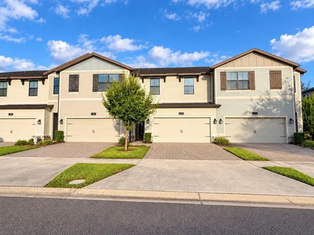 Front Exterior: Well-maintained townhome with a two-car garage and paver driveway.