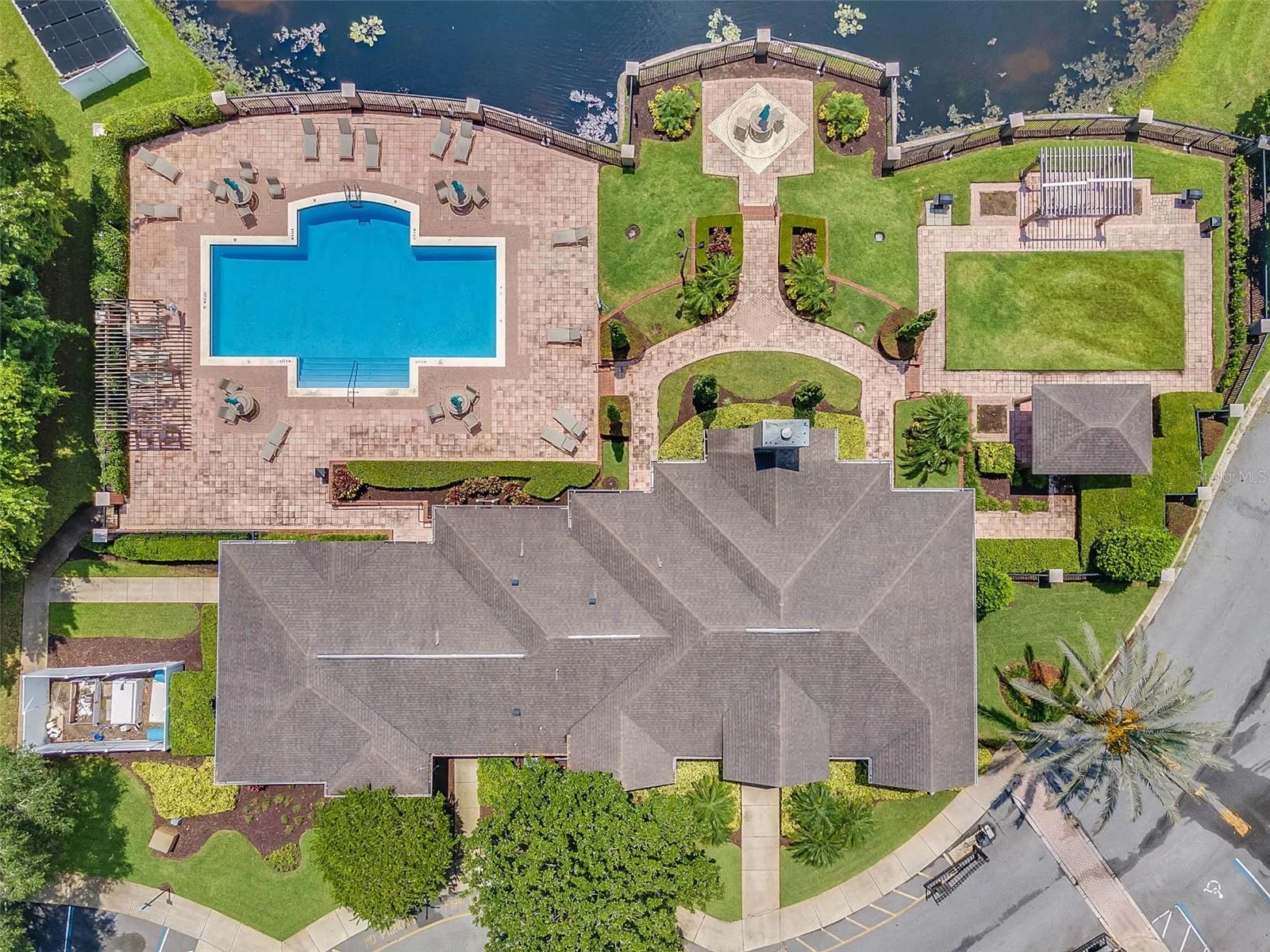 Overhead aerial view of the Sabal Point pool, pool deck, courtyard gardens, and clubhouse roof.