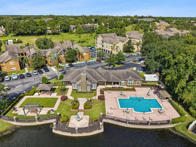Aerial view of the Sabal Point clubhouse, pool, parking area, and surrounding residential buildings.