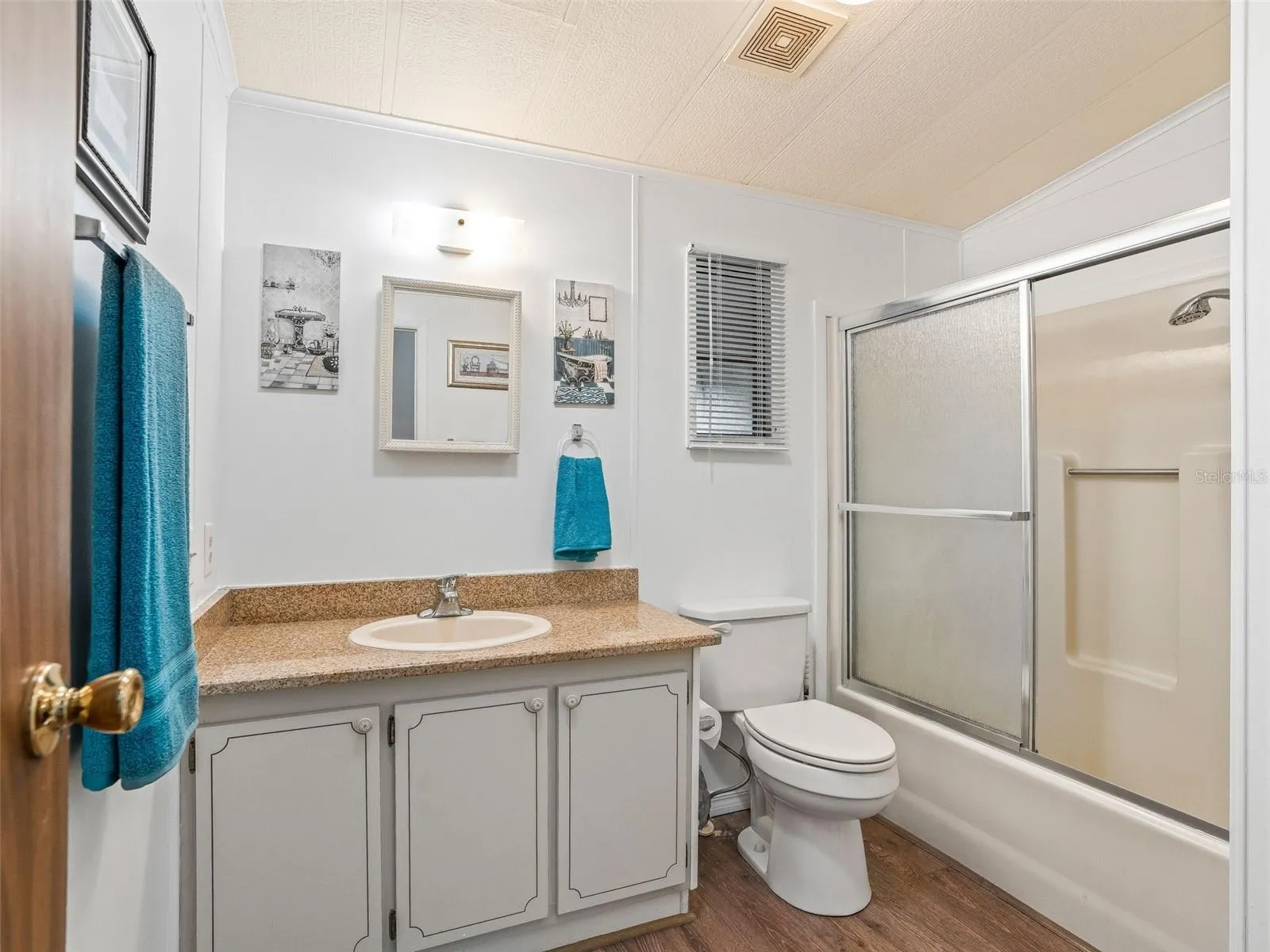 BATHROOM #2 - Features a single sink/vanity (L), COMFORT HEIGHT TOILET (Center) and TUB / SHOWER COMBO w/ SLIDING GLASS DOORS (R).