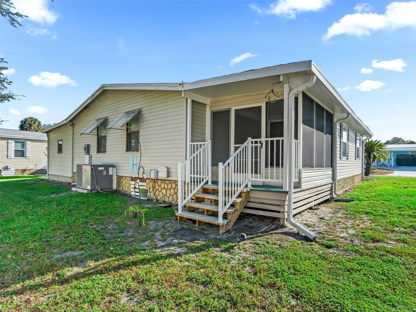 View of REAR OF HOME - Shows SCREEN ENCLOSED LANAI w/ rear stairs