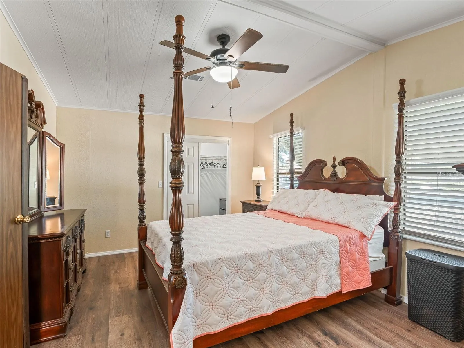 View of PRIMARY BEDROOM w/ DOUBLE DOOR ENTRY - Shows CATHEDRAL CEILING, ceiling fan, and large WALK-IN CLOSET (center back).