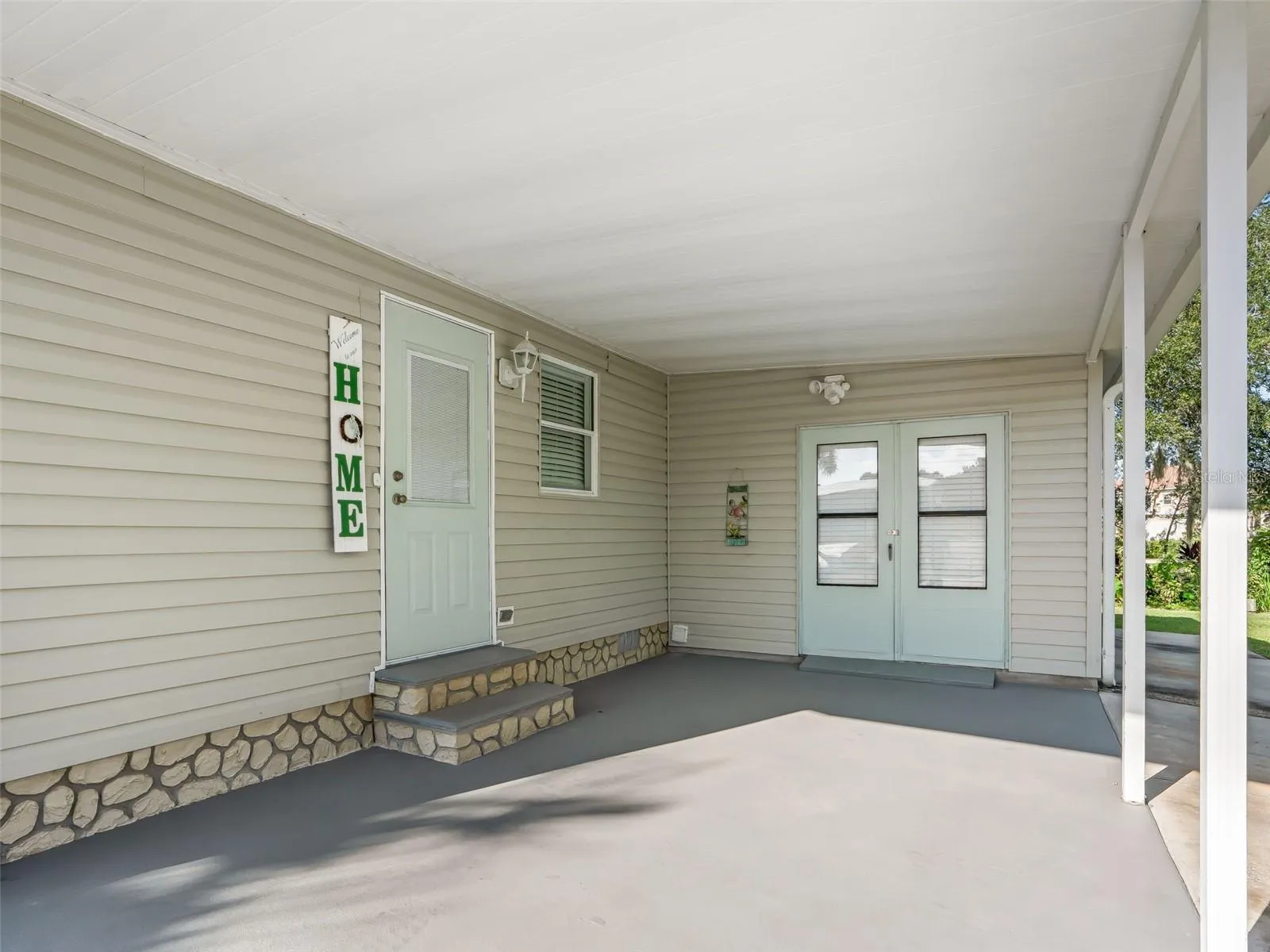 Single CARPORT w/ steps up to FRONT ENTRANCE (L) and double doors to GOLF CART GARAGE w/ concrete path &amp; side rea entry.