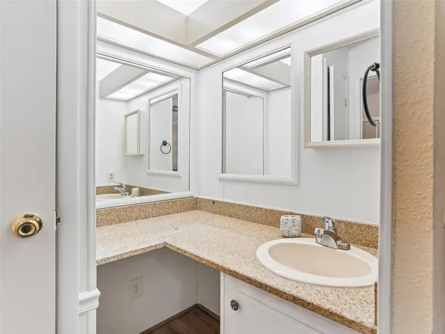 View of ENSUITE BATHROOM -  Shows CLOSET (L), MAKEUP SEATING AREA (Center L) and single sink/vanity (R)