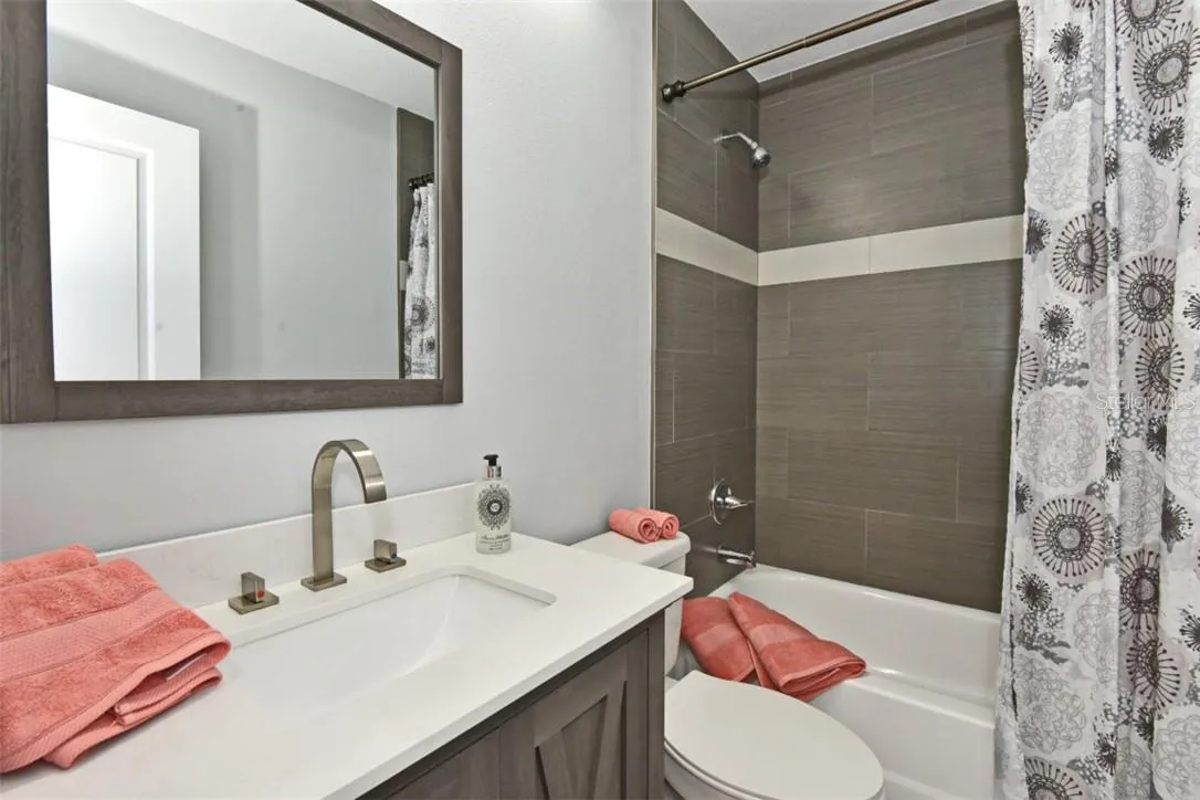 Raised ceiling above the tub/shower combo with all new tile, toilet and vanity with elegant brushed nickel hardware