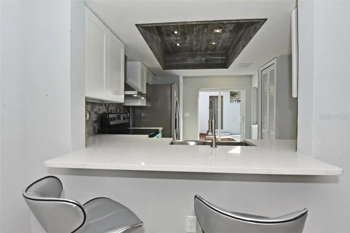 Sparkeling white quartz counter top with extended breakfast bar.
