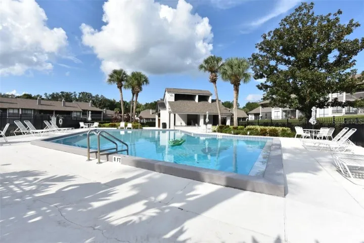 Sparkeling pool with lounge chairs, tables and chairs for fun time in the sun.