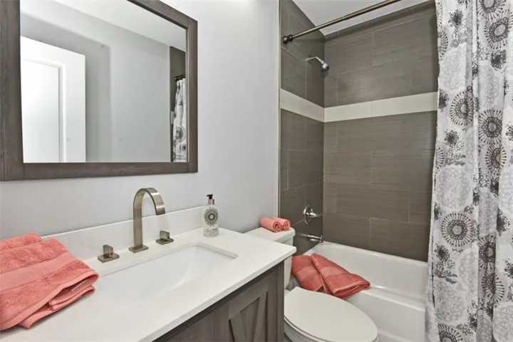 Raised ceiling above the tub/shower combo with all new tile, toilet and vanity with elegant brushed nickel hardware