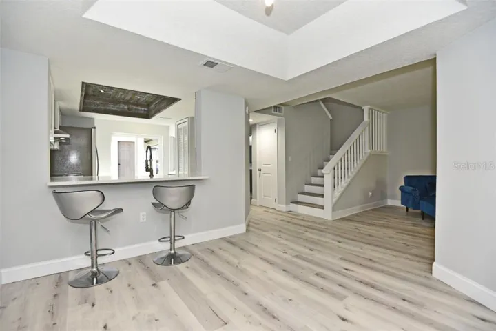 View from the dining room to the kitchen, foyer with storage room under the stairway.