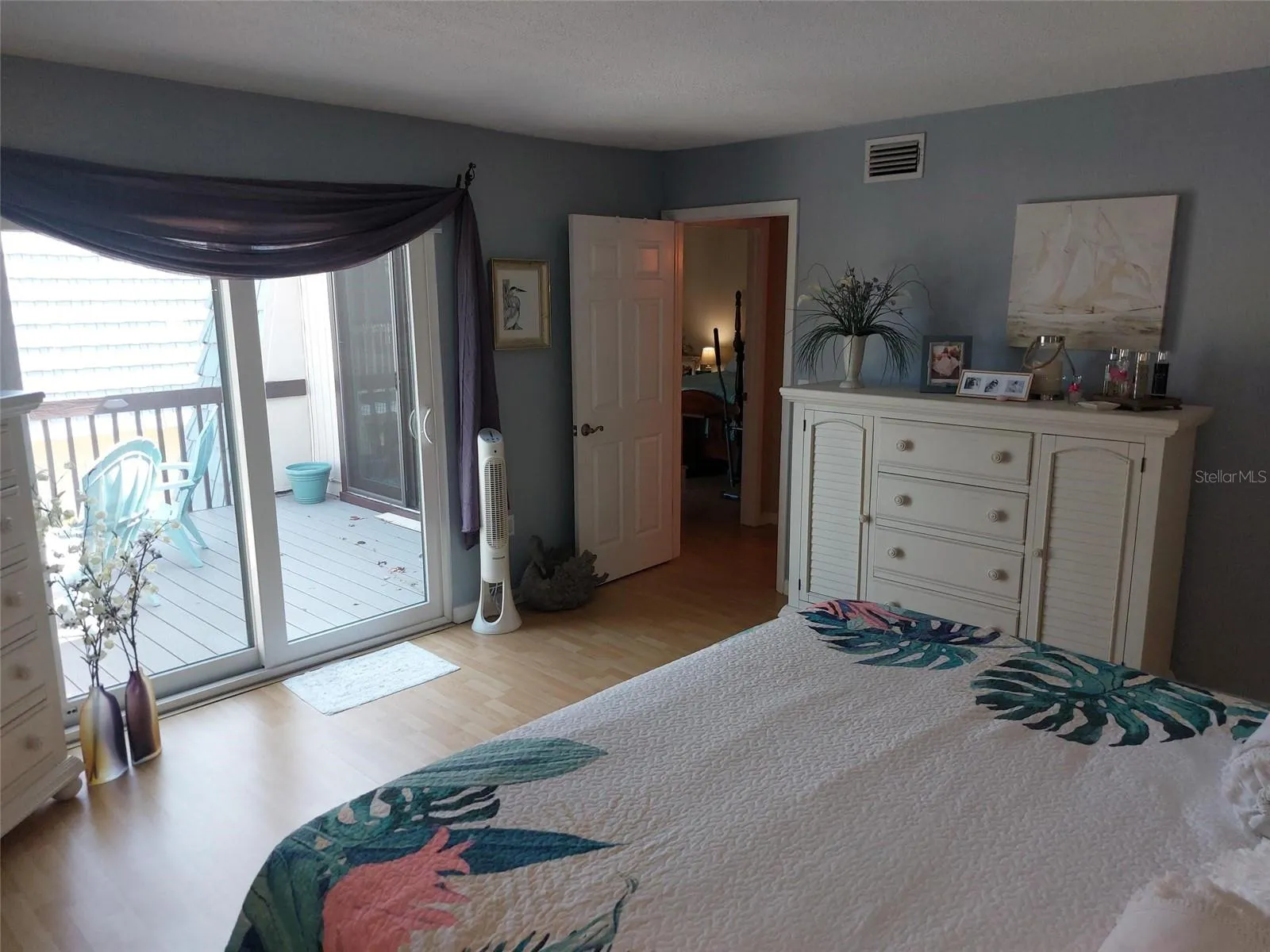 Staged primary bedroom and view of the upstairs patio.