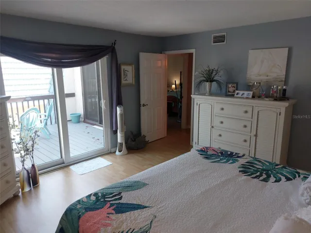 Staged primary bedroom and view of the upstairs patio.