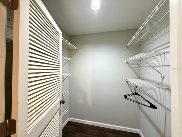 Walk-in closet in primary with plenty of shelving or room for additional storage furniture