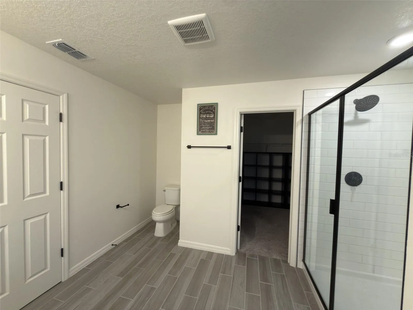 Primary bathroom facing walk in closet