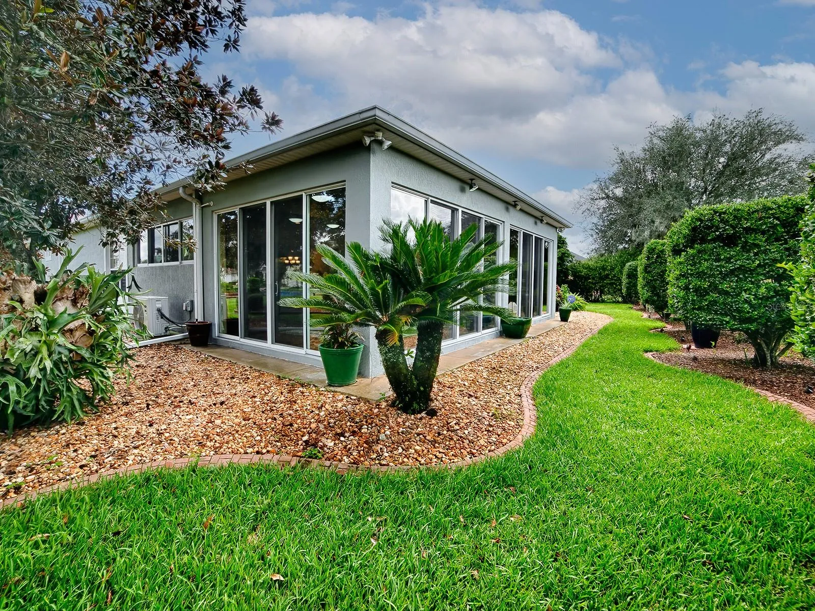 THE BACK OF THE HOME - LOVELY LANDSCAPING WITH CURBING AND ROCK BEDS.