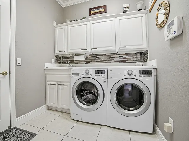 EXPANDED LAUNDRY ROOM OFFERS THE SAME LOVELY DETAILS AS THE KITCHEN WITH FRONT LOAD WASHER AND DRYER.