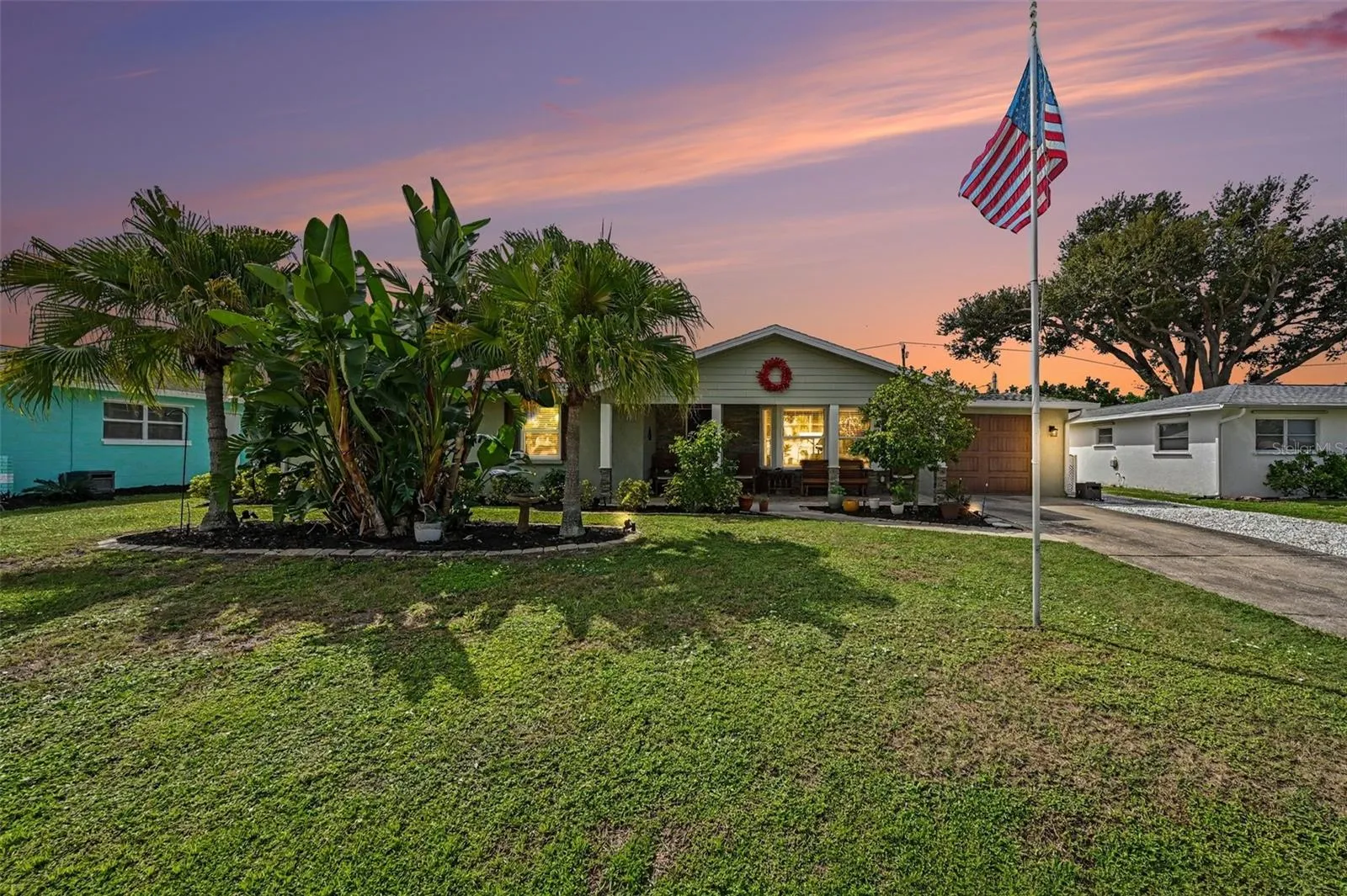 Twilight view of the front exterior and tropical landscaping at 412 Redwood Road, Venice, Florida