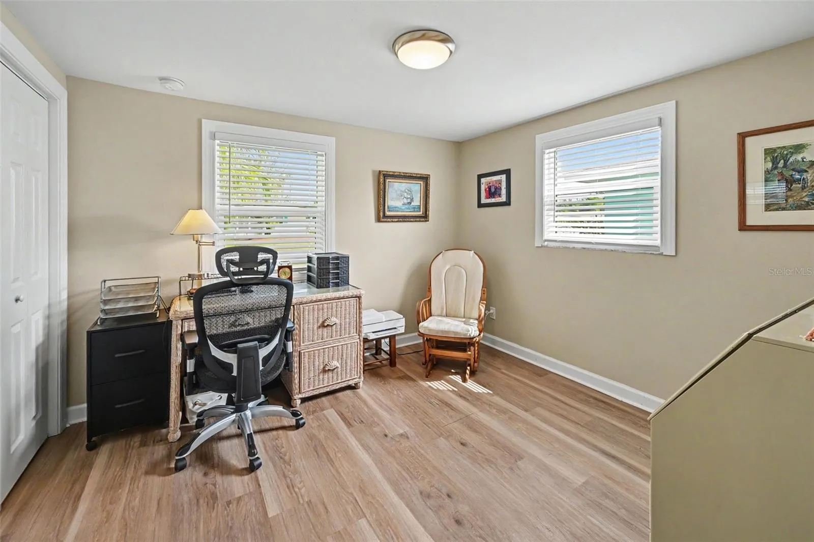 Bedroom currently utilized as a bright home office with two windows and wood-look flooring at 412 Redwood Road, Venice, Florida